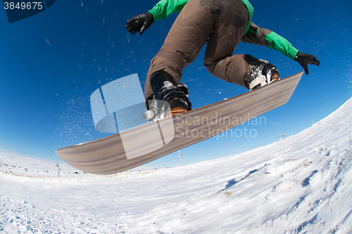 Image of Snowboarder jumping against blue sky