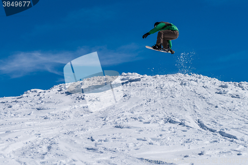 Image of Snowboarder jumping against blue sky