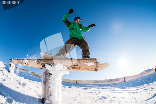 Image of Snowboarder sliding on a rail