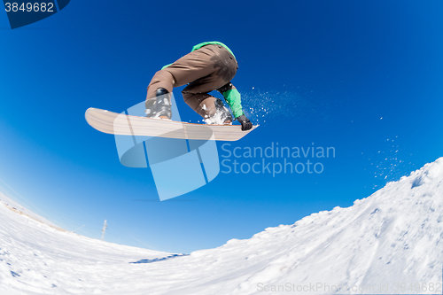 Image of Snowboarder jumping against blue sky