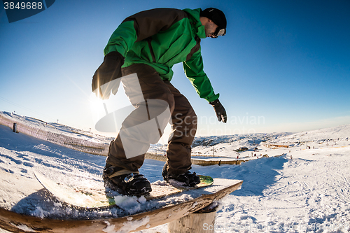 Image of Snowboarder sliding on a rail