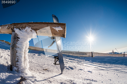 Image of Snowboard leaning on a wood rail