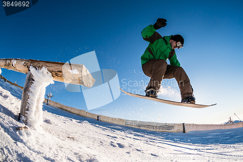 Image of Snowboarder jumping against blue sky