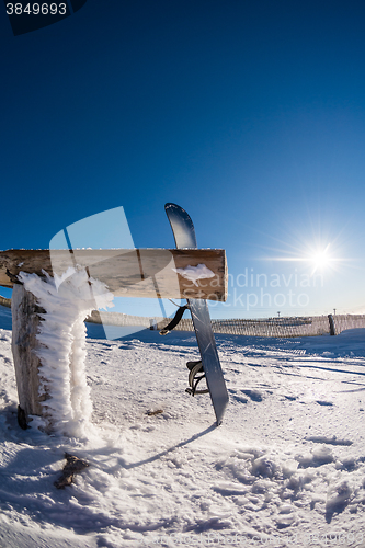 Image of Snowboard leaning on a wood rail
