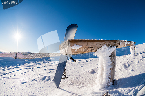 Image of Snowboard leaning on a wood rail