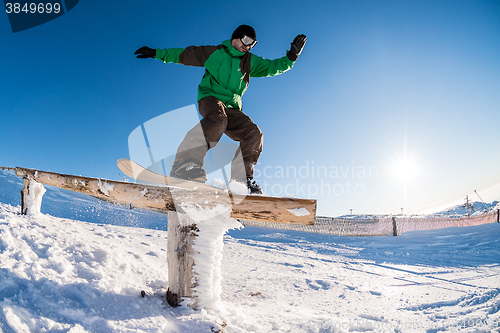 Image of Snowboarder sliding on a rail