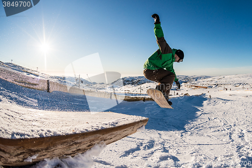 Image of Snowboarder jumping against blue sky