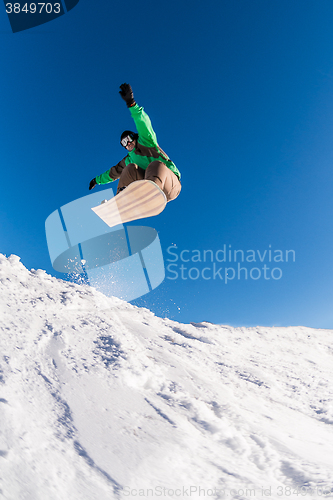 Image of Snowboarder jumping against blue sky