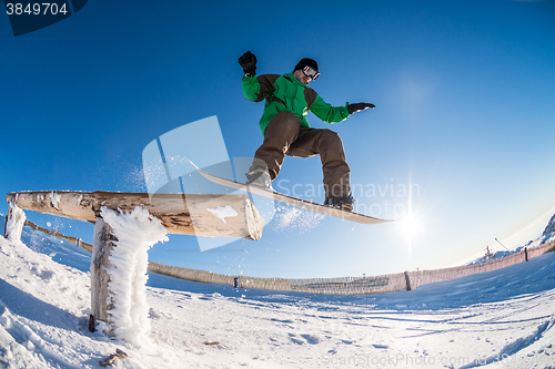 Image of Snowboarder jumping against blue sky