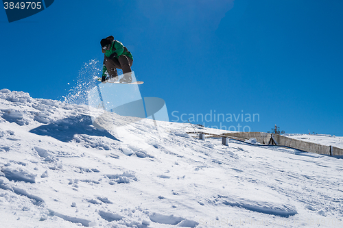 Image of Snowboarder jumping against blue sky