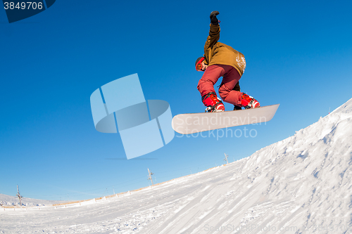 Image of Snowboarder jumping against blue sky