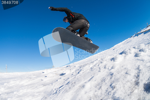 Image of Snowboarder jumping against blue sky