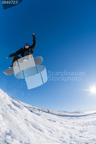 Image of Snowboarder jumping against blue sky