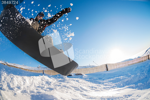 Image of Snowboarder jumping against blue sky