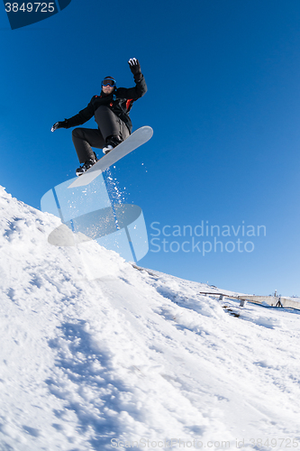 Image of Snowboarder jumping against blue sky