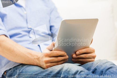 Image of close up of man working with tablet pc at home