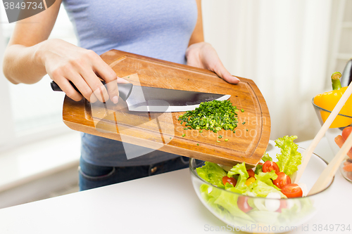 Image of close up of woman with chopped onion cooking salad