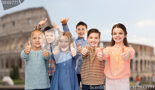 Image of children showing thumbs up over coliseum in rome