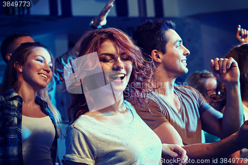 Image of happy friends dancing at night club