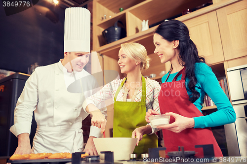 Image of happy women and chef cook baking in kitchen