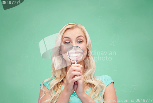 Image of happy young woman with magnifying glass