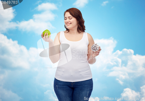 Image of happy plus size woman choosing apple or donut