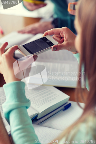 Image of student hands with smartphone making cheat sheet