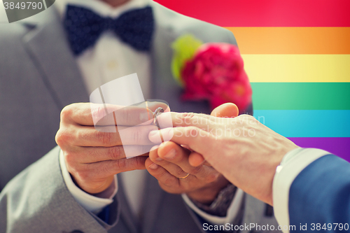 Image of close up of male gay couple hands and wedding ring