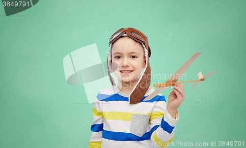 Image of happy little boy in aviator hat with airplane