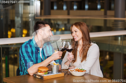 Image of happy couple dining and drink wine at restaurant