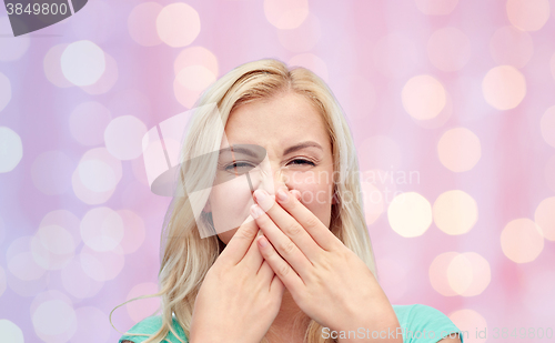 Image of young woman or teenage girl closing her nose