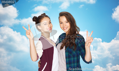 Image of happy teenage girls hugging and showing peace sign