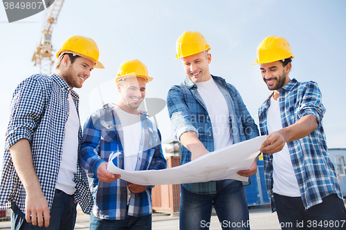 Image of group of builders with tablet pc and blueprint