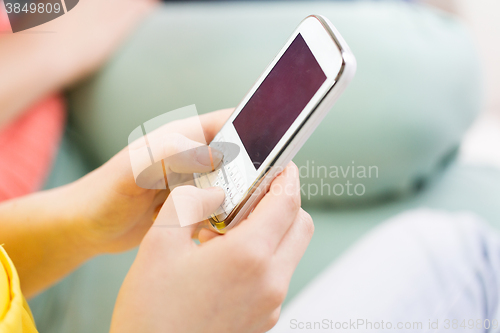 Image of close up of hands texting on smartphone at home