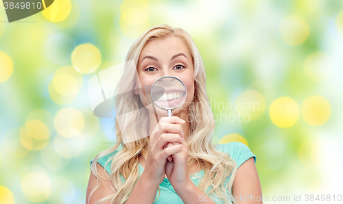 Image of happy young woman with magnifying glass