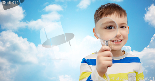 Image of happy little boy looking through magnifying glass