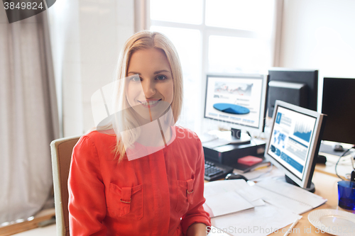 Image of happy creative female office worker with computers