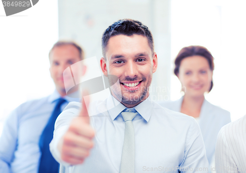 Image of businessman in office showign thumbs up