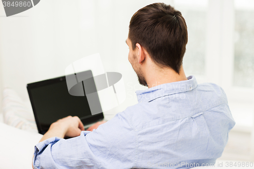 Image of close up of man typing on laptop computer at home