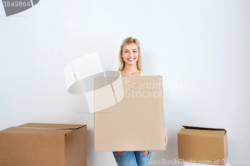 Image of smiling young woman with cardboard box at home