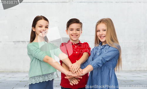 Image of happy children with hands on top
