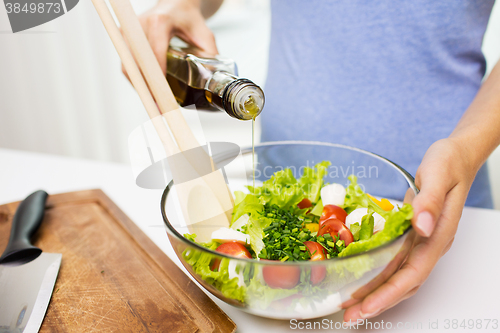 Image of close up of woman cooking vegetable salad at home