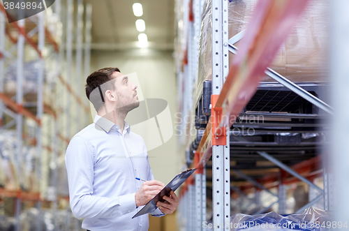 Image of businessman with clipboard at warehouse