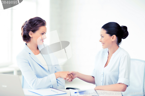 Image of businesswomen shaking hands in office