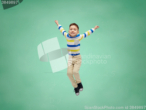 Image of happy little boy jumping in air over school board