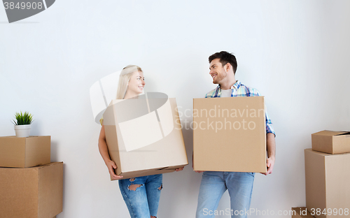 Image of smiling couple with big boxes moving to new home