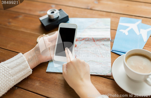 Image of close up of traveler hands with smartphone and map