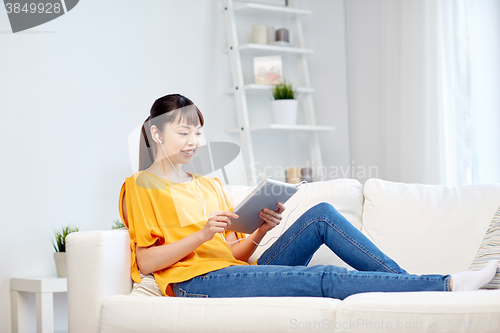 Image of happy asian woman with tablet pc and earphones