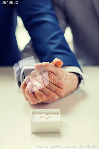 Image of close up of male gay couple and wedding rings