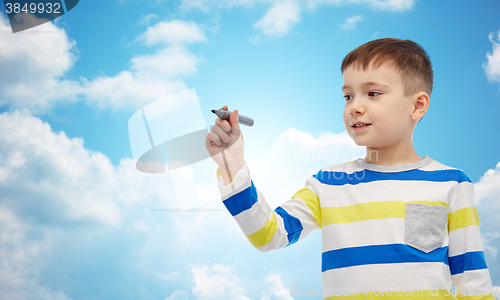 Image of little boy drawing or writing with marker